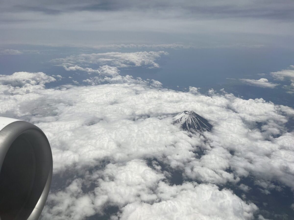 飛行機から見る富士山の写真。頂上だけが見えています。