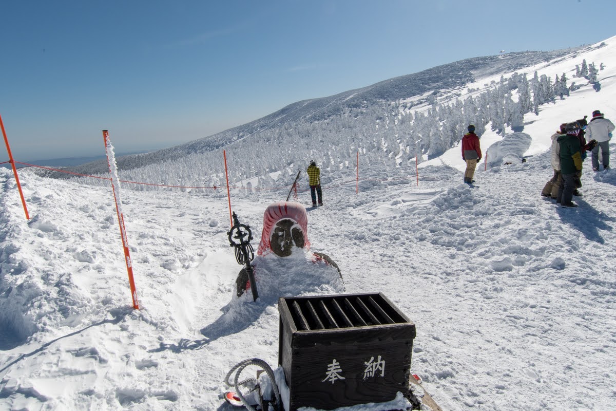 雪に埋まったお地蔵さんの写真。首から上しか出ていません。